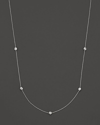 A white gold necklace with five bezel-set diamond stations; with signature ruby accent. Designed by Roberto Coin.