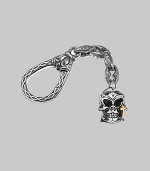 Skull-motif charm with a solid 18k gold cross accent on an engraved sterling silver clasp. About 4 long Made in USA